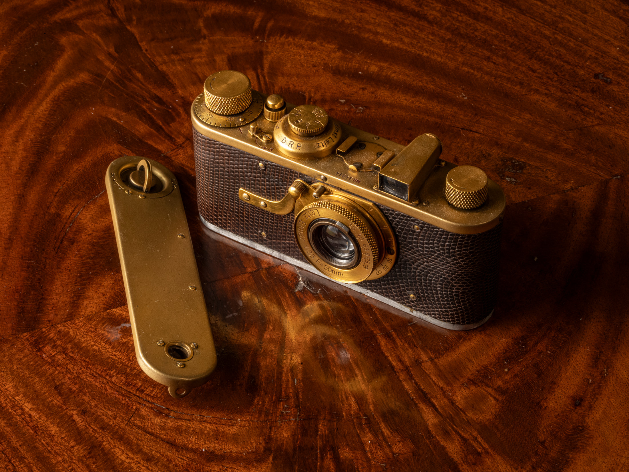 A brass Leica on a mahogany desk